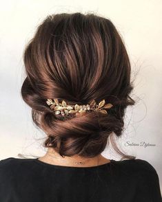 a woman wearing a gold hair comb with leaves on it