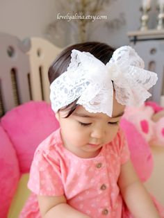 A beautiful lace bow headband suitable for all ages! Bow is approximately 5" wide attached to a 2" wide stretch lace. Offering different kinds of gem at the center of the bow to create a a diverse look.  Currently, photos are showing gem #1 and #2.  ⭐️Please note, gem sizes are different, therefore the result of the overall bow look may be slightly different than in photos. Also, due to the nature of this bow type, the shape/drape may slightly vary as well. Bow may look bigger in photos due to t Cute Adjustable Headband For Wedding, Cute Adjustable Headband For Weddings, White Adjustable Hair Accessories, Adjustable White Lace Hair Accessories, Cute White Headband With Pink Bow, White Matching Headband For Baptism, White Hair Accessories With Matching Headband For Baptism, White Bow Headband For Wedding, White Lace Headband For Party