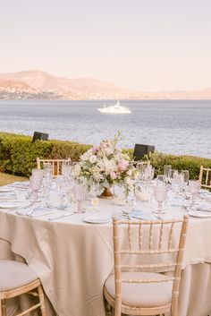 the table is set with white linens and flowers