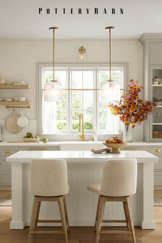 two stools sit at the center of a kitchen island in front of a window