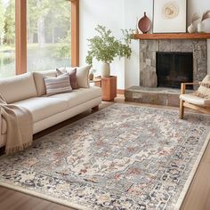 a living room filled with furniture and a large rug on top of a hard wood floor