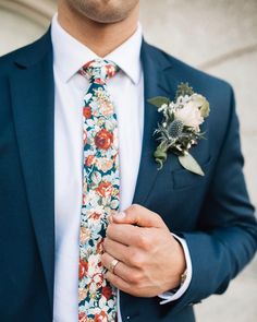 a man wearing a suit and tie with flowers on it