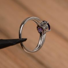 It is a natural amethyst ring. The main stone is 7mm*7mm round cut, weight about 1.25 carats. The basic metal is sterling silver and plated with rhodium. To change the metal to a solid gold (white/rose) or platinum is also available, please ask for a quotation if you want. You can also go to my shop Home for more elegant rings: https://www.etsy.com/shop/godjewelry?ref=hdr_shop_menu More amethyst rings: https://www.etsy.com/shop/godjewelry?ref=seller-platform-mcnav&section_id=20709248 Customi Adjustable Silver Solitaire Birthstone Ring, Purple Cubic Zirconia Birthstone Ring, Elegant Purple Solitaire Birthstone Ring, Elegant Purple Birthstone Ring With Round Cut, Elegant Purple Round Cut Birthstone Ring, Round Amethyst Diamond Ring, Sterling Silver Open Ring With Prong Set Birthstone, Amethyst Round Cut Birthstone Ring For Anniversary, Silver Round Birthstone Promise Ring