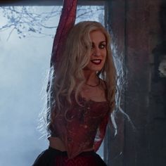 a woman with long blonde hair wearing a red corset