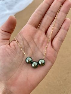 This necklace features three beautiful genuine Tahitian Pearls floating on a satellite chain. PLEASE NOTE: The genuine Tahitian Pearls will vary in shape, size and color and will have natural occurring birthmarks and or pits. They are as nature intended and part of the natural beauty of the pearls. The pearls will range and measure from 8mm to 10mm. These are stock photos, the necklace you receive will be similar but different. All White Sand Jewelry is handcrafted in Hawaii and comes in a hand Cheap Adjustable Pearl Necklace For Beach, Affordable 8mm Bead Pearl Necklace, Luxury Tahitian Pearl Pendant Jewelry, Luxury Tahitian Pearl Round Beads Jewelry, Luxury Tahitian Pearl Jewelry With Pearl Charm, Luxury Tahitian Pearl Necklace With Pearl Pendant, Luxury White Gold Tahitian Pearl Jewelry, Hawaiian Jewelry Necklace, Sand Jewelry