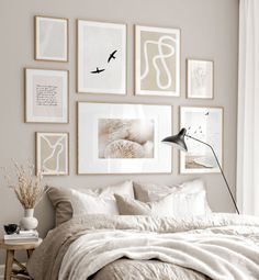 a bed with white sheets and pillows in a bedroom next to pictures on the wall