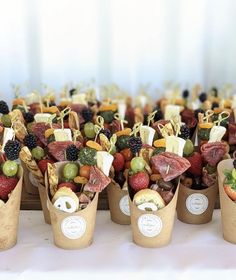 a table topped with cups filled with different types of fruit and vegtables