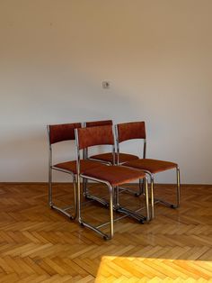 three chairs sitting on top of a hard wood floor