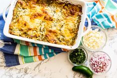 a casserole dish with cheese and other ingredients on the counter next to it