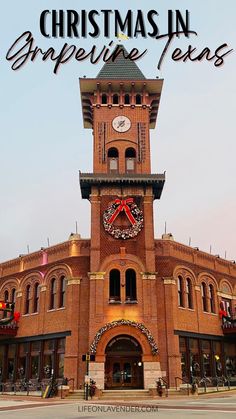 an old brick building with a clock tower and christmas wreath on the top, in front of it