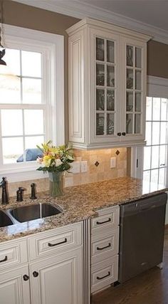 a clean kitchen with white cabinets and granite counter tops is seen in this image from the front view