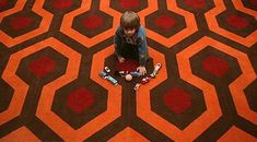 a person sitting on the floor in front of a carpet with hexagons