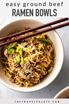 a bowl filled with noodles and chopsticks on top of a marble countertop