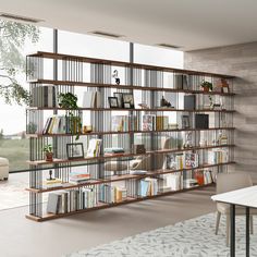 a living room filled with lots of furniture and bookshelves next to a window