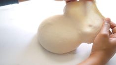 someone is peeling an onion on a white surface