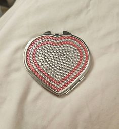 a heart shaped purse sitting on top of a bed