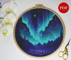 a cross - stitch pattern with the image of an aurora bore in blue and green