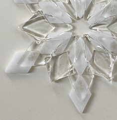 a snowflake made out of glass sitting on top of a white countertop