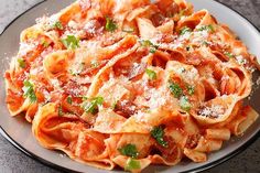 a plate full of pasta with sauce and parmesan cheese on top, sitting on a table