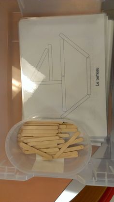 several wooden sticks are in a plastic container