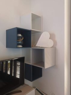 a tv sitting on top of a wooden shelf next to a wall mounted air conditioner