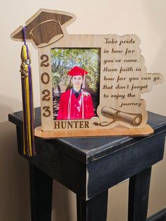 a photo frame with a graduation cap and tassel on it sitting on a table