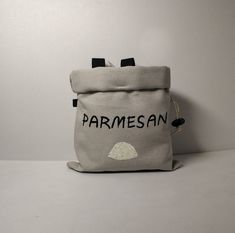 a bag with the word parmesan on it sitting against a white wall,