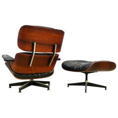 an eames lounge chair and ottoman with black leather upholstered on the back