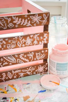 a wooden crate sitting on top of a table covered in paint