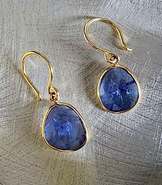 Tanzanite is said to stimulate intuition and perception. In these earrings I have combined a pair of delicate, Tanzanite rose cut gems, with 18kt gold. The earrings are light in weight and eye catching. The stones measure 13mm x 11mm. The total length including ear wire is 1 inch. Just for you this item comes gift wrapped. Luxury Birthstone Earrings For Formal Occasions, Luxury Formal Earrings With Birthstone, Luxury Formal Birthstone Earrings, Formal Tanzanite Teardrop Jewelry, Tanzanite Gemstone Earrings For Formal Occasions, Formal Tanzanite Teardrop Earrings, Formal Tanzanite Gemstone Earrings, Yellow Gold Tanzanite Jewelry With Matching Earrings, Formal Sapphire Earrings With Birthstone