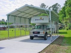 a truck is parked in front of a covered camper at a park with grass and trees