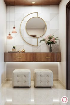 a bathroom with two stools and a mirror on the wall above it, along with flowers in vases