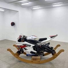 a white motorcycle parked on top of a wooden sled