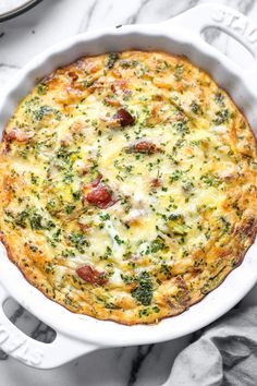 a white casserole dish with broccoli and cheese