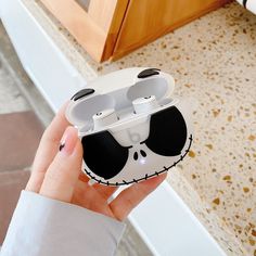 a person holding an airpods case in their hand, with the lid up to show it's design