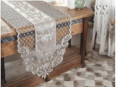 the table is covered with white lace and has an ornate design on it's edge