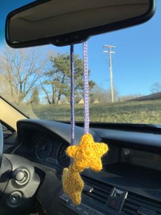 a stuffed animal hanging from the dashboard of a car