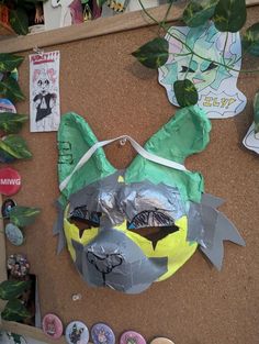 a bulletin board covered in paper and other items that include masks, magnets, and stickers