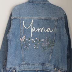 a jean jacket with the word mama written on it and flowers painted on the back