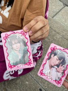 a person holding two small cards with pictures on them