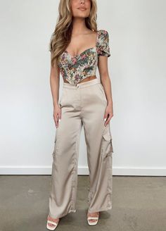 Our Sand Cargo Satin Pants are expertly tailored to ensure comfort and sophistication all in one. Featuring a high-waisted, wide leg cut with trendy cargo pockets and a stretchy elastic waistband, these pants offer a perfect balance of softness and style. The neutral satin finish, button and zipper closure, and subtle Silky Cargo Pants Outfit, Satin Cargo Pants Outfit Dressy, Satin Cargo Joggers Outfit, Elegant Beige Satin Bottoms, Brown Satin Cargo Pants Outfit, Satin Finish, Satin Pants, Cargo Pant, Casual Pants