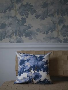 a bed with two pillows on it and a wallpapered headboard in the background