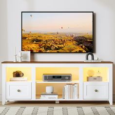 a flat screen tv sitting on top of a white entertainment center in a living room