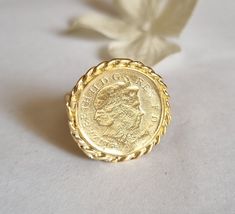 Gold coin ring, coin pinky ring, gold signet ring, coin signet ring, cocktail ring vintage style coin ring, vintage gold ring, pinky ring This gold coin ring is made of a British 5p coin which was decorated with braided gold filled wires and attached to a wide handmade band, creating a lovely signet ring. The coin coin ring is designed in a vintage style and is available both in 14k gold plating over brass or silver as well as sterling silver (see last photo). The ring is a great cocktail ring a Vintage Coin Signet Ring As Gift, Vintage Coin Shaped Signet Ring Gift, Vintage Coin Signet Ring For Gift, Vintage Engraved Coin Signet Ring, Hallmarked Coin Shaped Signet Ring As Gift, Gold Coin-shaped Signet Ring For Gift, Gold Coin Shaped Signet Ring, Gold Coin-shaped Engraved Signet Ring, Gold Coin Shaped Signet Ring For Gift