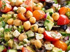 a salad with chickpeas, tomatoes, cucumbers and olives