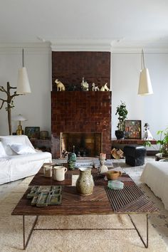 a living room filled with furniture and a fire place next to a white couch in front of a fireplace