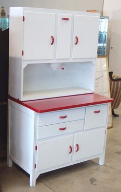 a white cabinet with red top and drawers