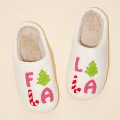 a pair of white slippers with the word fala written on them and christmas trees