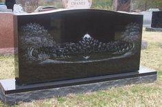 a headstone with trees on it in a cemetery