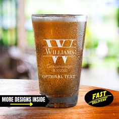 a pint glass sitting on top of a wooden table next to a sticker